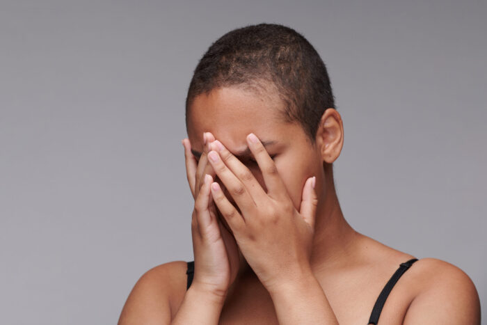 Frau bedeckt ihr Gesicht mit den Händen. Moralische Verletzungen wecken Schuldgefühle und Scham. Doch man kann Schritte zur inneren Versöhnung gehen. Mit einem neuen Blick auf die eigene Biografie.